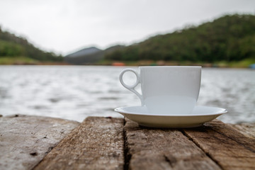 Hot coffee in a cup of coffee that is laid on the floor Morning wooden balcony was placed for drinking coffee before work. The idea of drinking caffeinated beverages will make the brain alert.
