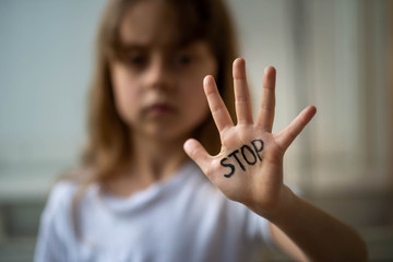 The child makes a stop gesture with his hand. Stop domestic and child abuse.