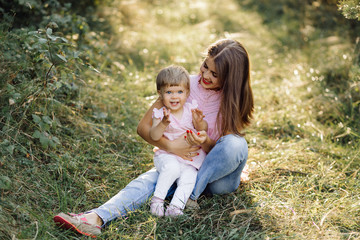 Fototapeta premium Young mother with her adorable little baby in forest