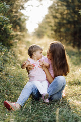 Fototapeta premium Young mother with her adorable little baby in forest