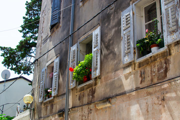 View of traditional croatian old building with flower pots in the windows, in the old town of Porec...