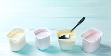 Fototapeta na wymiar Different yogurts on wooden table empty copy space.Fresh youghurt in plastic.