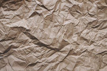 Crumpled light brown wrapping vintage paper background. The texture of cardboard made from recycled materials.