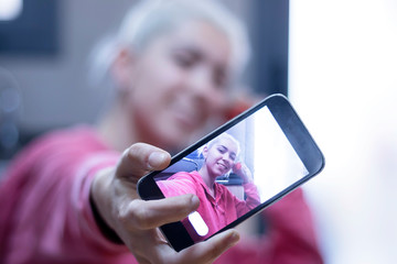 Image of charming optimistic woman wearing casual clothes taking selfie photo and at the kitchen