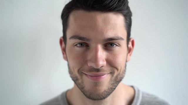 Portrait of a caucasian young handsome man looking at camera and smiling.