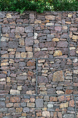 stone wall behind a metal grid