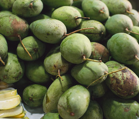 A lot of fresh green coconuts stacked together.