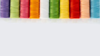 Top view laying out multi-colored threads on an isolated background, copy space. Needlework concept, handmade