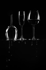 silhouette of wine glasses on a black background. water drops