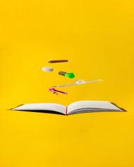 Levitating school supplies for math - notebook, pen, ruler, pencil, divider and eraser on yellow background. Concept of education and creativity