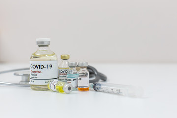 Concept of a Coronavirus covid -19 trial Multiple Vaccine Bottles with Needles and Stethoscope.