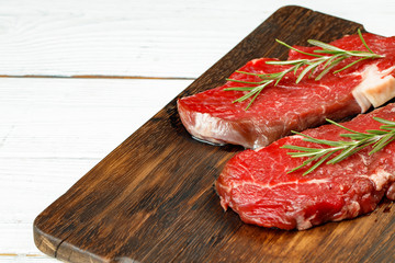 Barbecue veal steaks with rosemary on wooden board