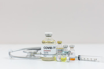 Concept of a Coronavirus covid -19 trial Multiple Vaccine Bottles with Needles and Stethoscope.