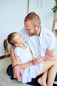 Adorable little girl in white dress hugging loving father