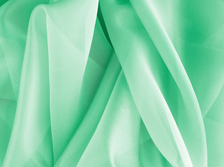 Textiles and textures. Crumpled green organza drapery close-up. The background fabric - obrazy, fototapety, plakaty