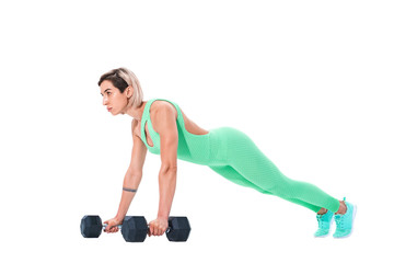 Fit sexy woman doing plank exercise on dumbbells isolated over white background.