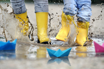 in die Regenpfützen springen