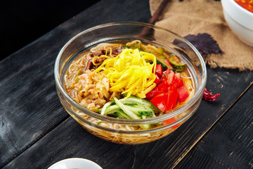 Korean cold soup kuksi with vegetables and beef