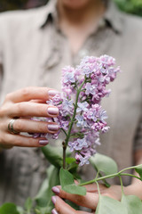 Fototapeta premium a bouquet of lilacs with woman hands