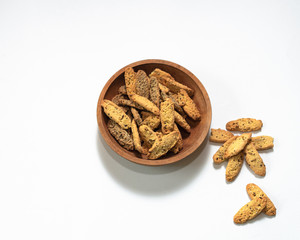 Crisp shortbread cookies with cannabis seeds in a wooden plate on a white background