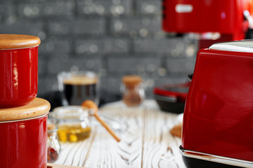 Close up photo of a red toaster on a kitchen table