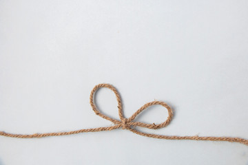 Flax jute rope with bow close-up on a white background