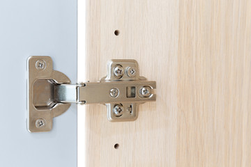 Polished Stainless door hinge on a cabinet door for interior design.