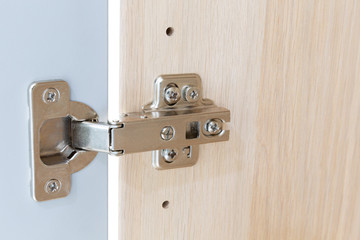 Polished Stainless door hinge on a cabinet door for interior design.