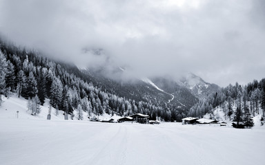 Black and white photo of the rocky cloudy valley in the Tirol Alps.