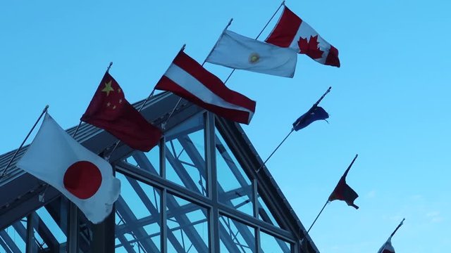 National flags on a roof, assembly or meeting of multiple nations. International concept. 