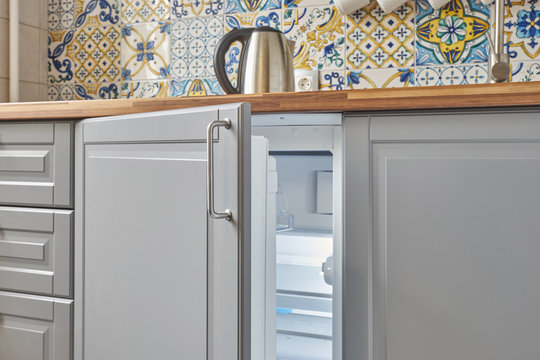 compact built-in refrigerator under the countertop in the kitchen