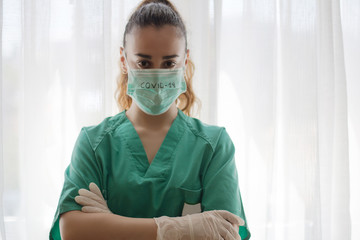 Health professional equipped with operating room clothes and in the mask the word COVID-19