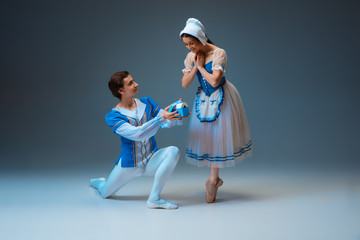 Expensive gift for modern Cinderella - toilet paper during its deficit. Young and graceful ballet dancers during show on studio background. Art, motion, flexibility, inspiration concept.
