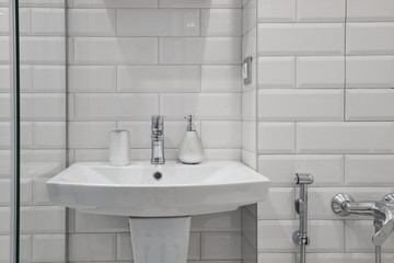 a glass of toothbrushes on the bathroom sink