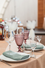 Tables are set for a party or wedding reception. Luxurious elegant dinner in a restaurant. Glasses and dishes and flowers.