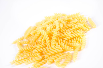 Raw fusilli pasta on a white background