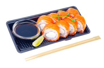 Black plate with rolls with salmon and soy sauce, Japanese cuisine