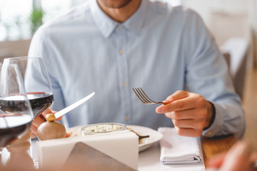Young man eating delicious food in restaurant