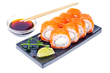 Black plate with rolls with salmon and soy sauce, Japanese cuisine