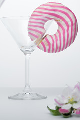  A flower in a glass close-up for a screensaver. In the background is a donut glass. And next to it is a pink flower.