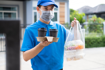 Food Delivery man wearing mask handing plastic bags shopping online from supermarket to client service customer front house, express grocery when coronavirus covid19 new normal lifestyle.