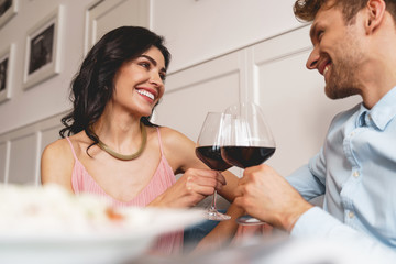 Beautiful young couple toasting with wine in cafe