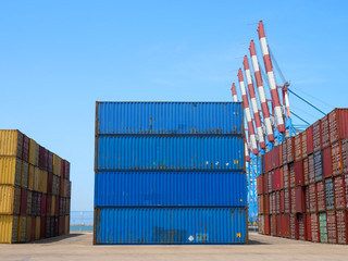 Fototapeta premium Shipping Containers in various colors stacked at a holding platform.