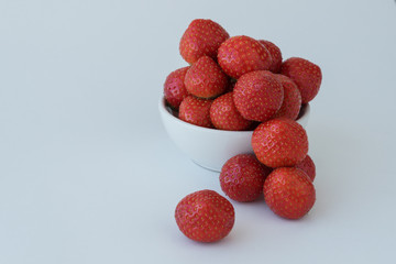 white round plate with red delicious strawberry on white background. Copy space for text. Healthy vitamin food concept