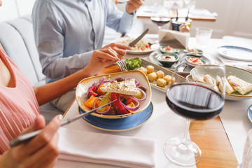 Young lady and gentleman having dinner in restaurant