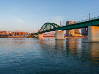 Old rail Sava bridge, connecting two Belgrade shores divided by river Sava. Bright sunny day with some clouds on the horizon.