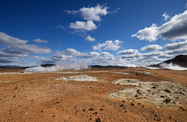 Natural steam rising from volcanic vents in the earth. Namafjall - geothermal area in field of Hverir. Landscape which pools of boiling mud and hot springs. Tourism and natural attractions in Iceland.