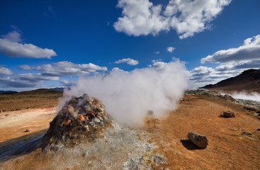 Natural steam rising from volcanic vents in the earth. Namafjall - geothermal area in field of...
