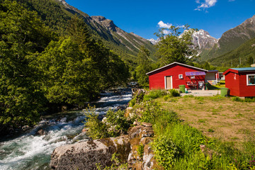 Picturesque scene of Urke village and Hjorundfjorden fjord, Norway. Drammatic sky and gloomy mountains. Landscape.