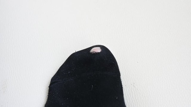 Torn black sock. Leaking black sock on an isolated background.